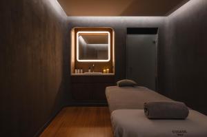 two beds in a room with a sink and a mirror at Hotel Les Haras By Stay Collection in Strasbourg