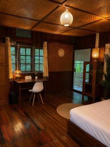 a bedroom with a bed and a desk and a table at Thai house in Chaweng in Nathon Bay