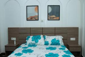 a bedroom with a bed with blue flowers on it at Residences ACC in Abomey-Calavi