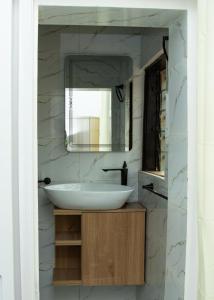 a bathroom with a white sink and a mirror at Residences ACC in Abomey-Calavi