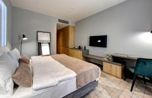 a bedroom with a bed and a desk with a computer at Hotel Emporia Mostar in Mostar