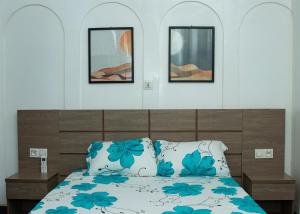 a bedroom with a bed with blue flowers on it at Residences ACC in Abomey-Calavi