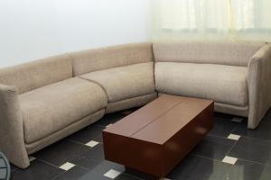 a brown couch with a coffee table in a room at Residences ACC in Abomey-Calavi
