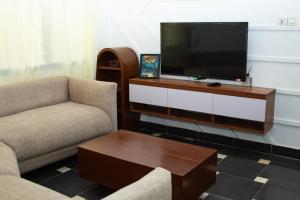 a living room with two chairs and a flat screen tv at Residences ACC in Abomey-Calavi