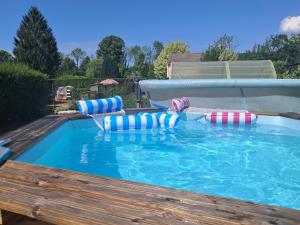 a large swimming pool with inflatables in a yard at Chambres d'hôtes chez Peggy et Eric chambre indus in Équevillon