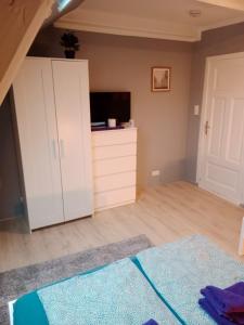 a bedroom with a white cabinet and a television at FördeFlats in Flensburg