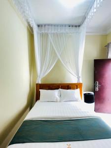 a bedroom with a bed with a canopy and white curtains at Hotel Abiron in Wanseko +9 photos