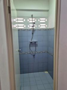 a bathroom with a shower with blue and white tiles at Sterappel Sun Stay in Paramaribo +2 photos
