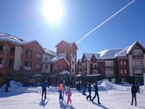 a group of people on skis in the snow near buildings at Snow apartments in Gudauri