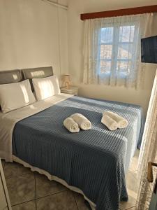 a bedroom with a bed with two towels on it at Ageon Amorgos in Amorgos