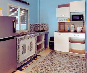 a kitchen with a sink and a refrigerator at Aura Home Kalasin in Kalasin