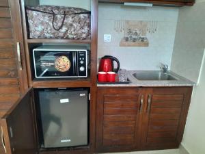 a small kitchen with a sink and a microwave at Woodford Ayubia in Ayubia