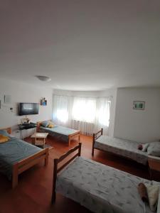 a living room with three beds and a tv at Apartmani Tea i Toni in Gradište