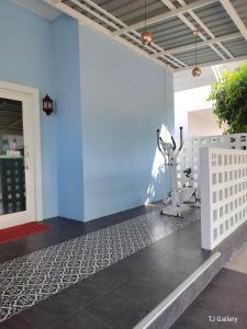 a fitness room with a blue wall and a treadmill at Aura Home Kalasin in Kalasin