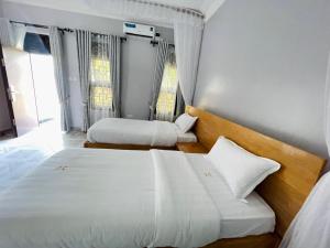 two beds in a hotel room with white sheets at Hotel Abiron in Wanseko
