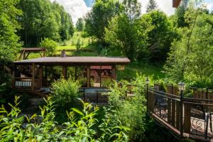 a house in the middle of a garden with a bridge at Коло Гір in Kolochava