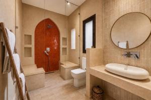 a bathroom with a sink and a toilet and a mirror at Riad privé Maskat, piscine, petit-déjeuners, proche Jemaa el-Fna in Marrakesh +35 photos