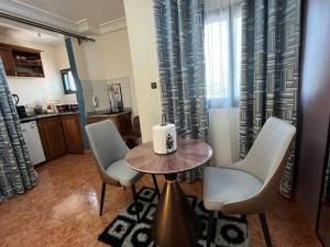 a room with a table and chairs and a kitchen at Regal Hotel Douala in Douala