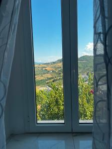 two windows in a room looking out at a view at La Casetta Noble House in Casoli +4 photos