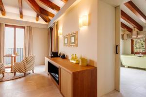 a living room with a desk and a bath tub at Gran Hotel Margalida by Annua Signature in Banyalbufar