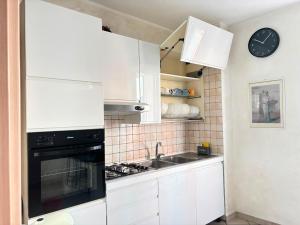 a kitchen with white cabinets and a stove top oven at Pasubio House appartamento in Campobasso +12 photos
