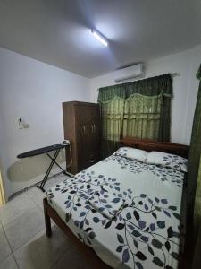 a bedroom with a bed and a desk in it at Sterappel Sun Stay in Paramaribo