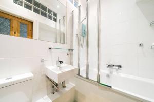 a white bathroom with a sink and a mirror at The Palais in Dundee +24 photos