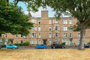 a large brick building with cars parked in front of it at The Palais in Dundee