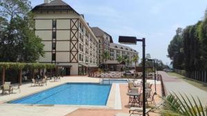 a hotel with a swimming pool in front of a building at Vista Azul Hotel Frente Pedra Azul in Pedra Azul