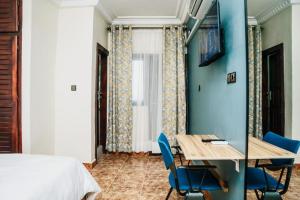 a room with a bed and a table and chairs at Regal Hotel Douala in Douala +25 photos