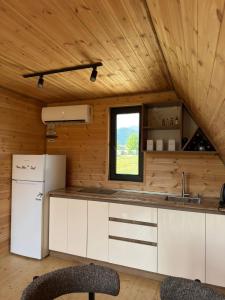 a kitchen with a white refrigerator and a window at Hillside Shilda in Shilda