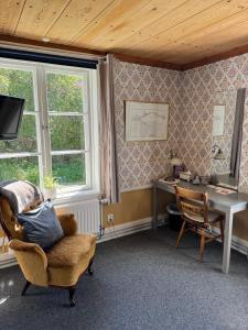 a room with a chair and a desk and a window at Wanbo Herrgård in Nedre Vanbo