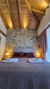 a bedroom with a large bed with two pillows at Stone Loft in Karpenisi