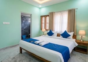 a bedroom with a large bed with blue walls at Das & Das Hotel in Bhubaneshwar