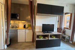 a small kitchen with a tv on a counter at Appart T2 pers Risoul Proche pistes in Risoul
