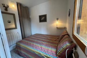 a bed in a small room with a window at Appart T2 pers Risoul Proche pistes in Risoul