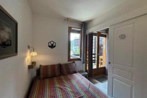 a small bedroom with a bed and a window at Appart T2 pers Risoul Proche pistes in Risoul