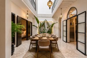 a dining room with a table and chairs at Riad privé Maskat, piscine, petit-déjeuners, proche Jemaa el-Fna in Marrakesh