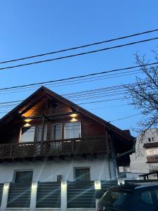 a wooden house with a balcony on the side of it at Casa Tofalvi in Sovata