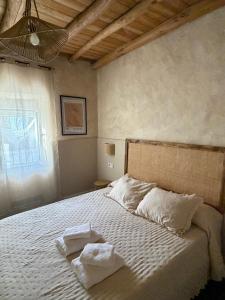 a bedroom with a bed with two towels on it at Casa Limón in Bodonal de la Sierra