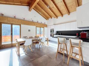 a kitchen with a table and chairs in a room at L Eau Vive Combles in Le Châble