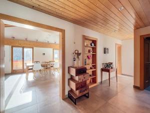 a living room with a table and a wooden ceiling at L Eau Vive Combles in Le Châble