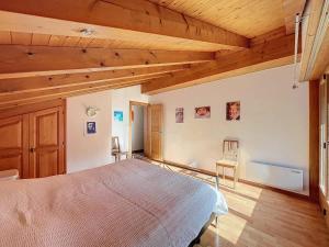 a bedroom with a bed in a room with wooden ceilings at L Eau Vive Combles in Le Châble