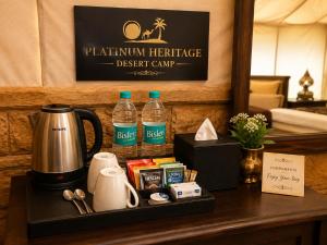 a table with a coffee maker and bottles of water at Platinum Heritage Desert Camp in Jaisalmer