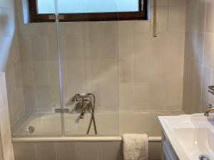 a bathroom with a bath tub and a sink at Ferienwohnung Tannenhöh in Todtmoos