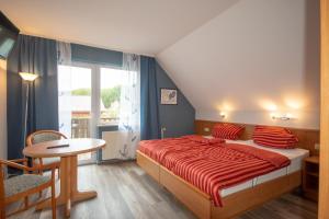 a bedroom with a bed and a table and a window at Strandhaus Malchow in Malchow