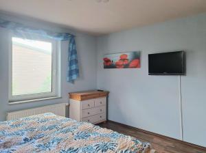 a bedroom with a bed and a television on the wall at Niederrheinhaus in Rheinberg