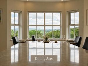 a dining area with a large table and windows at Sonas in Letterkenny