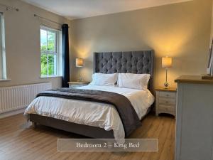 a bedroom with a large bed and two windows at Sonas in Letterkenny