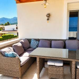 a couch and a table on a patio at Acharavi, villa next to the beach in Acharavi